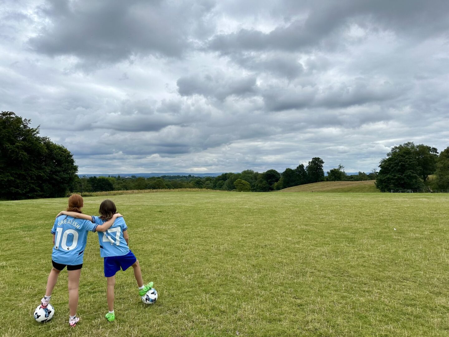 Two boys are playing soccer in a field.